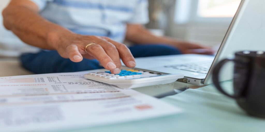 imagem de mão masculina apertando botão de calculadora