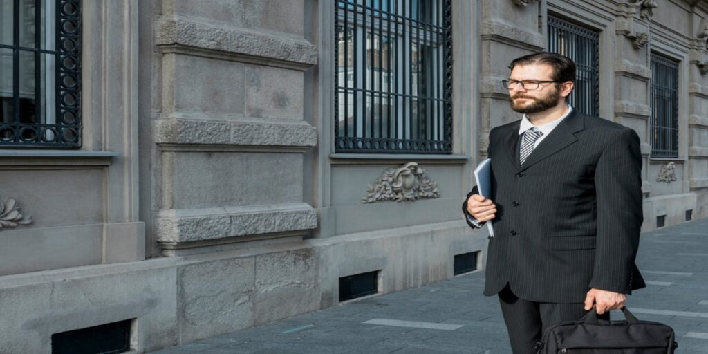 imagem de homem de terno ao lado de fora de tribunal