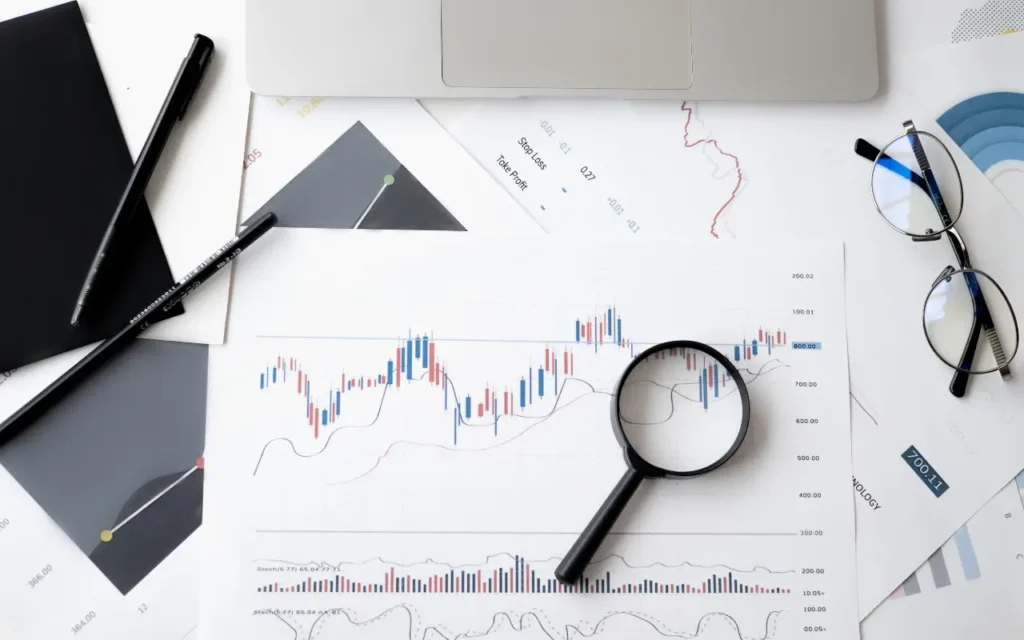 papéis em cima de uma mesa com gráficos e dados, fazendo referência aos relatórios de monitoramento de rede