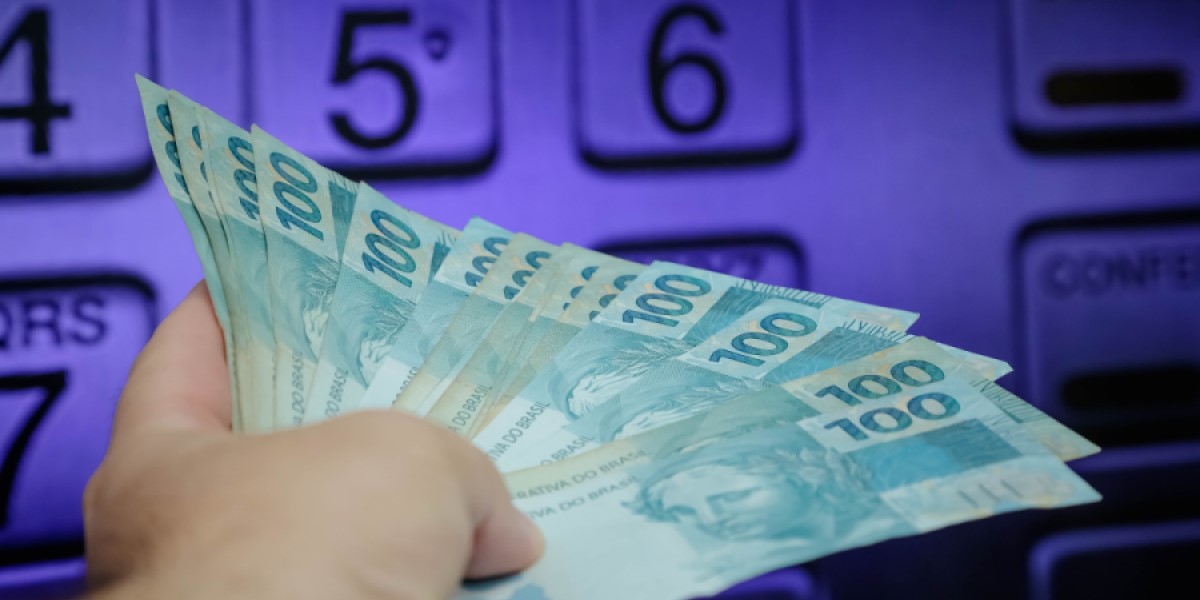 notas de cem reais na frente de um caixa eletrônico 