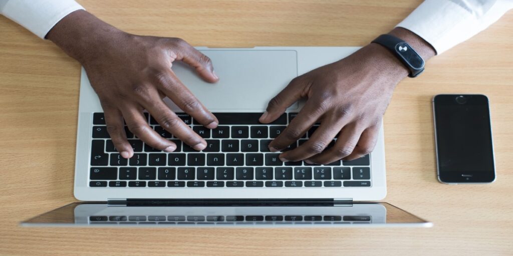 imagem de homem negro digitando em notebook