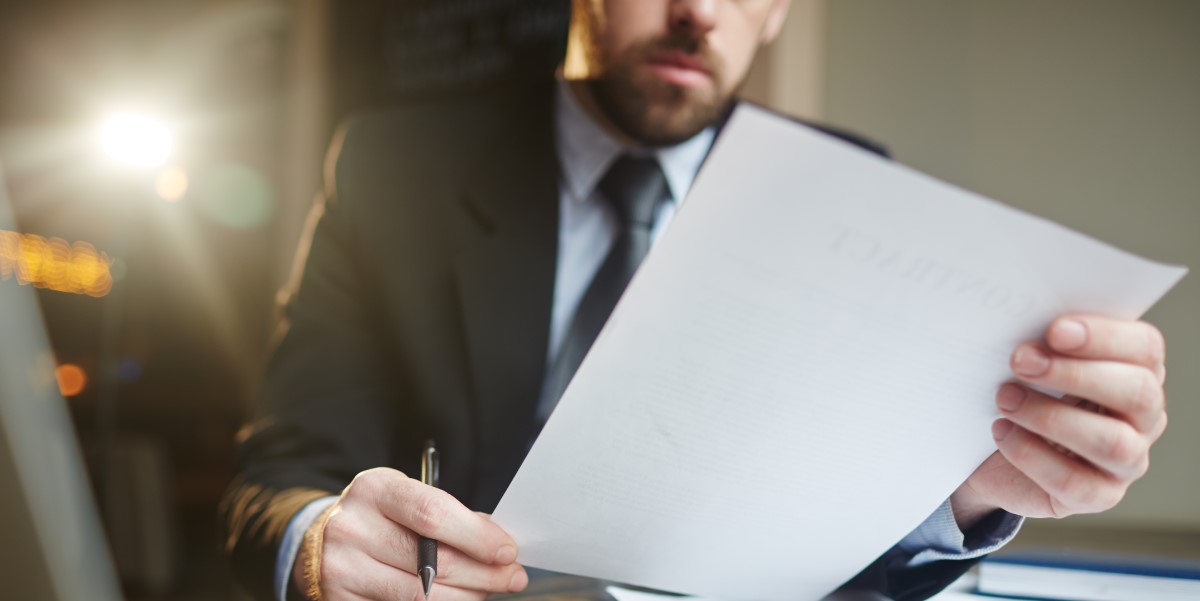 homem de terno analisando um documento