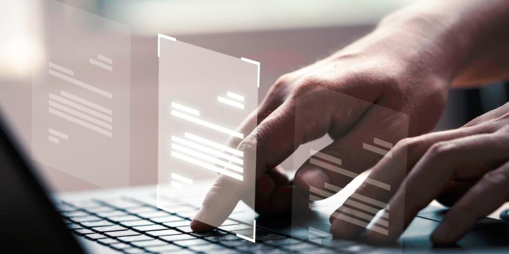 Teclado de notebook sendo digitado com olograma de informações