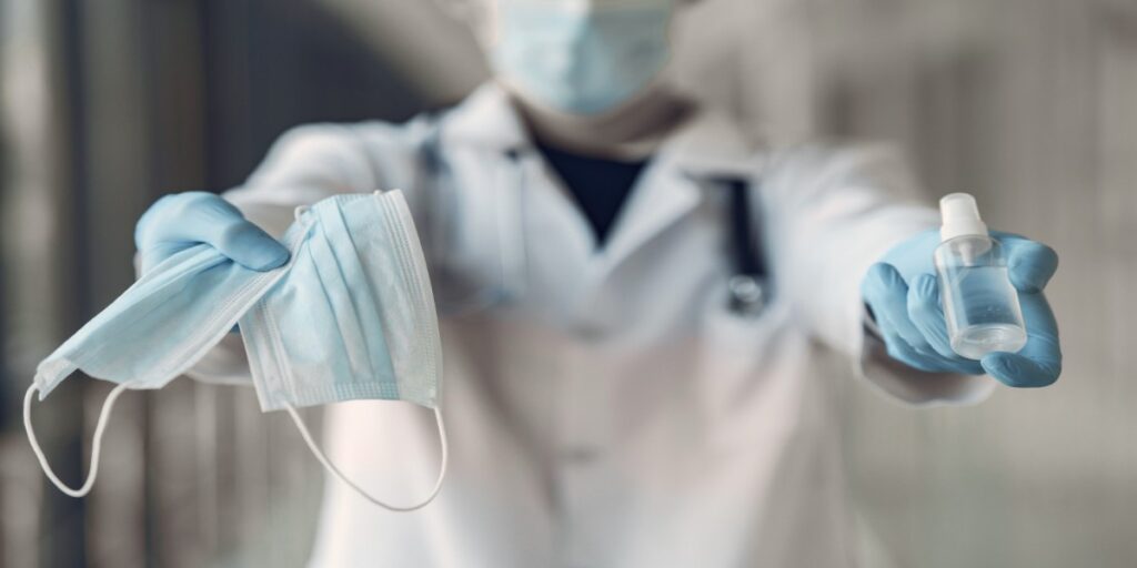 Imagem de médico oferecendo máscaras e alcool em gel