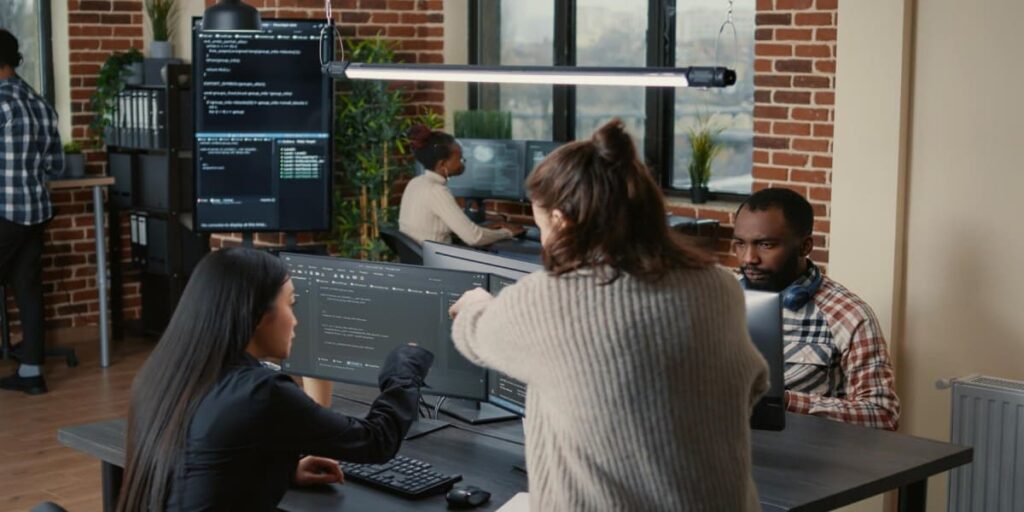 imagem de funcionárias se auxiliando em programação