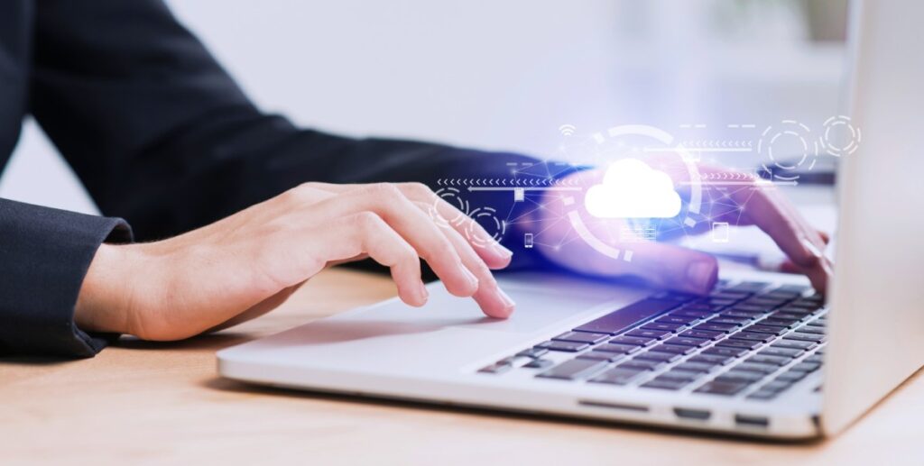 Pessoa usando um laptop com gráficos holográficos saindo da tela, simbolizando tecnologia avançada e inovação digital.