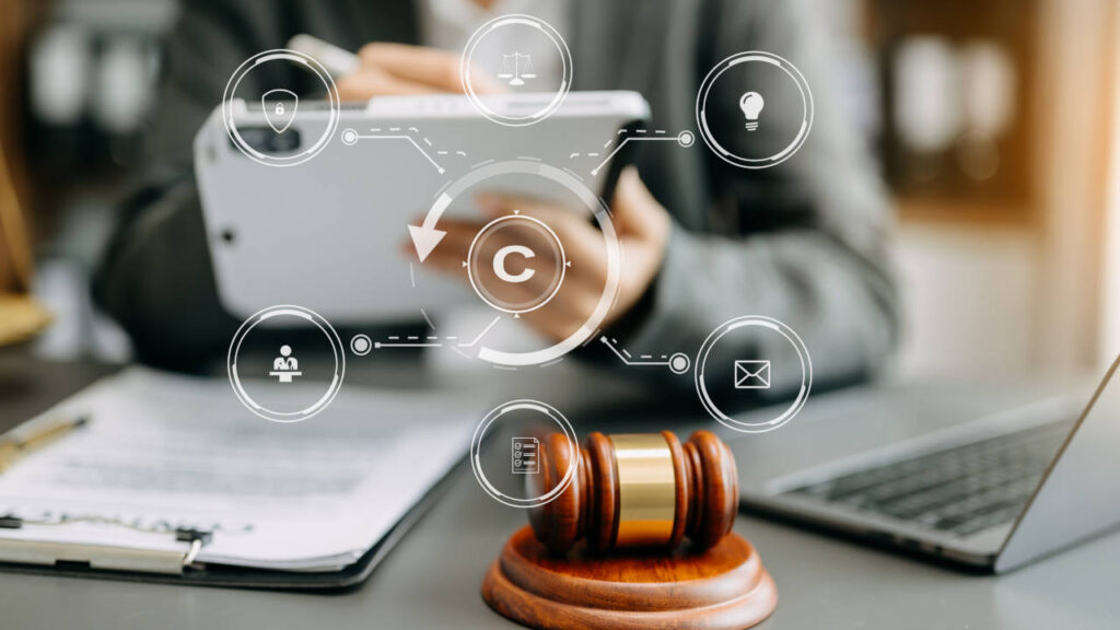 Gavel e ícones digitais representando direitos autorais em um ambiente de trabalho.