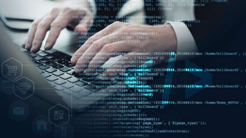 Imagem de um profissional digitando em um teclado de laptop, com uma sobreposição de código e ícones digitais, simbolizando trabalho em tecnologia e programação.
